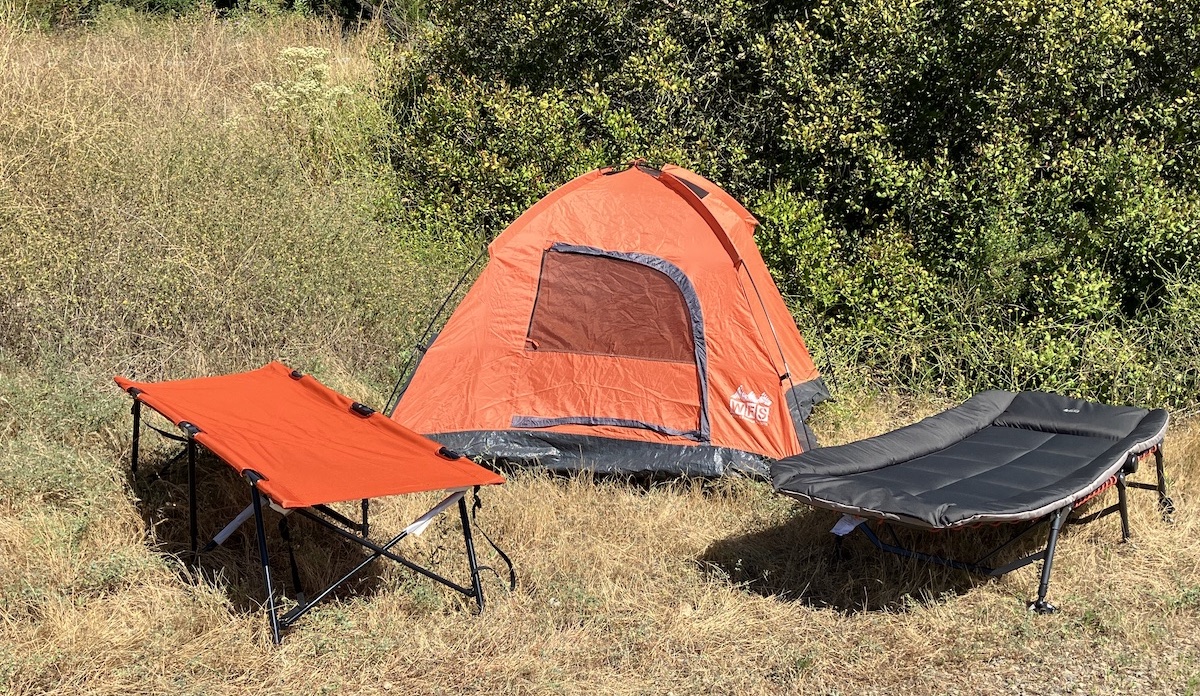 camping cots set up in front of a tent 