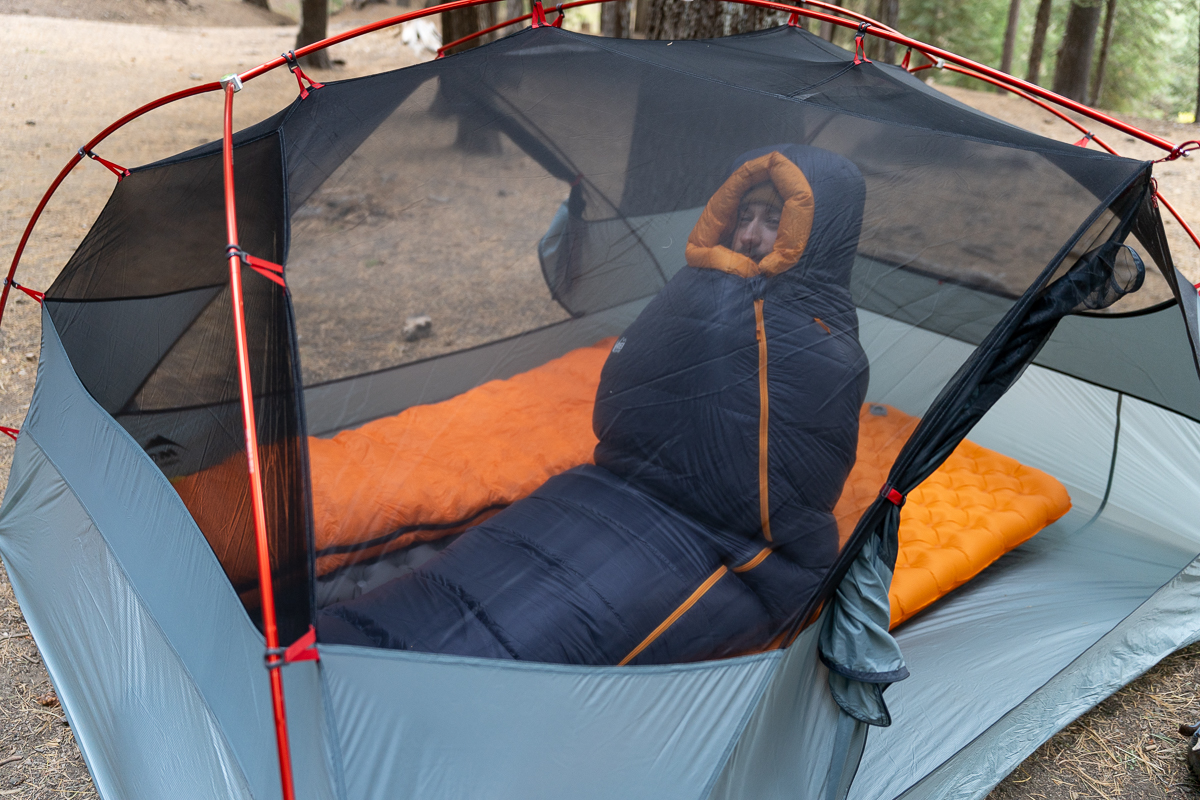 man sitting up in camping tent