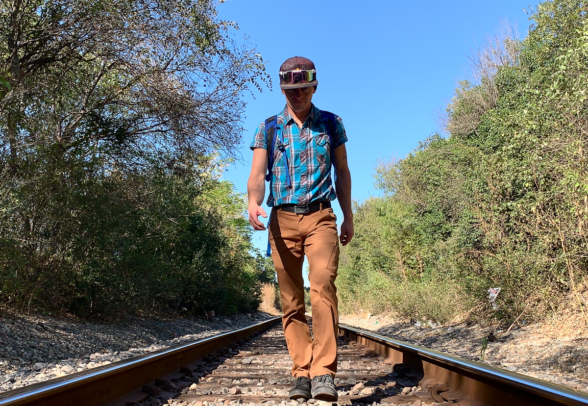 man walking on railroad tracks