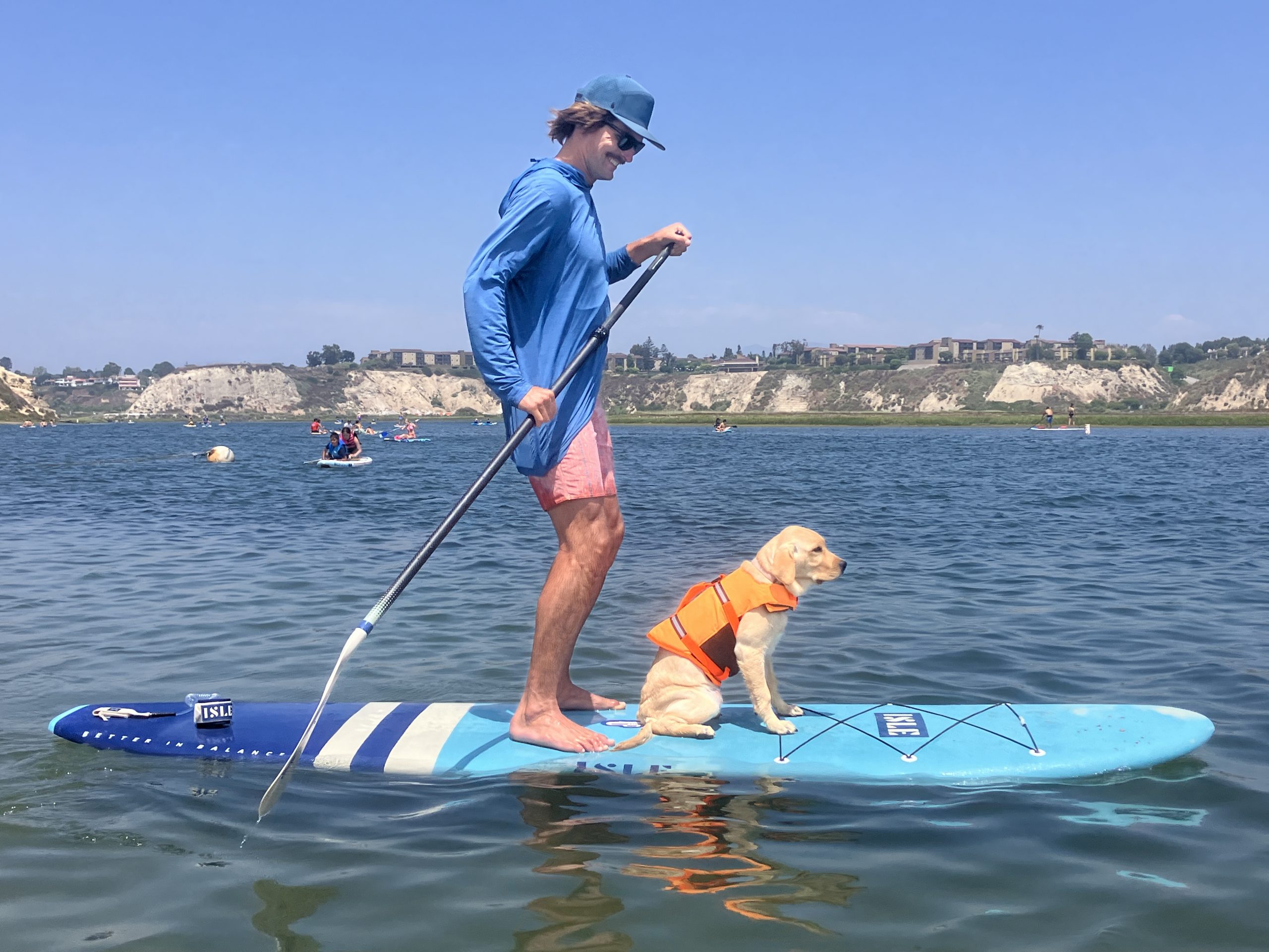 a man and a puppy paddle boarding