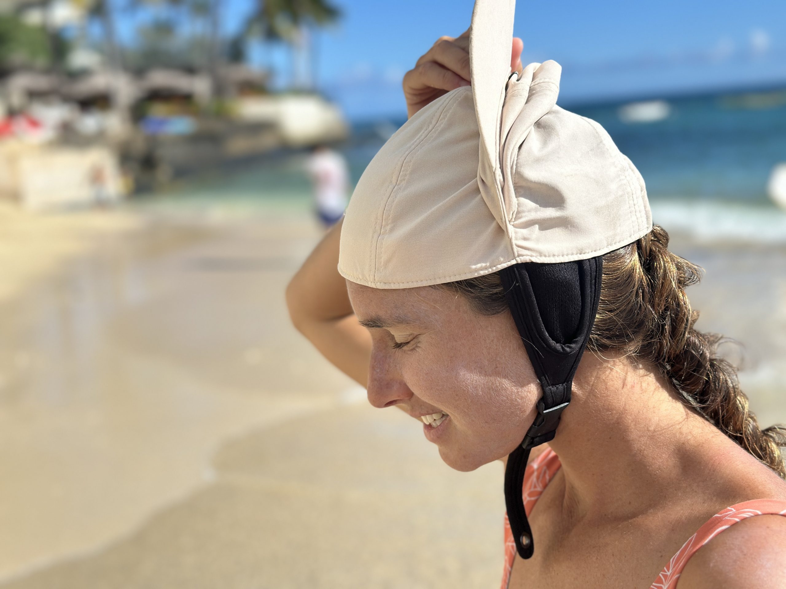 a woman putting on a surf hat