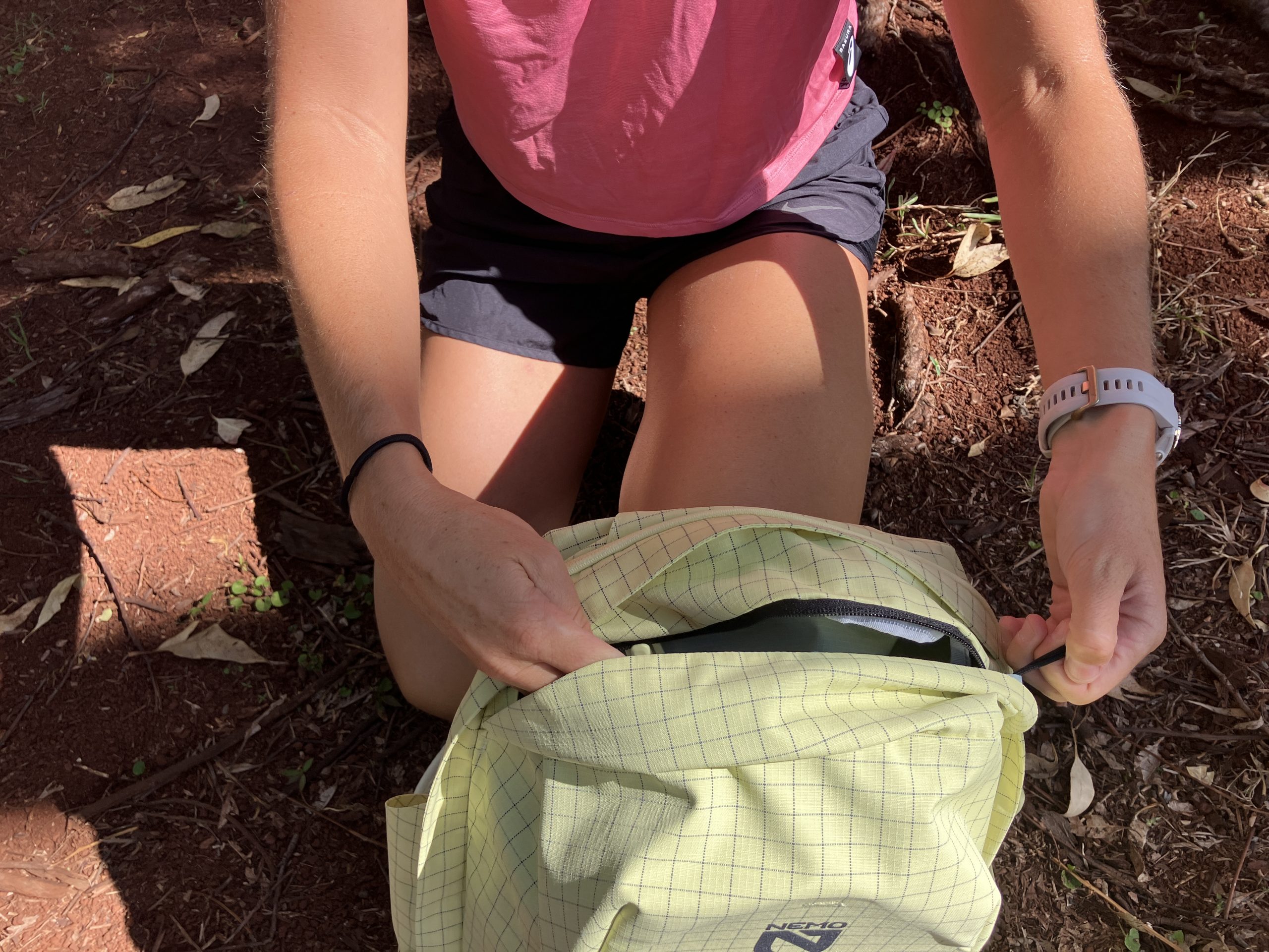 a woman unzipping a backpack 