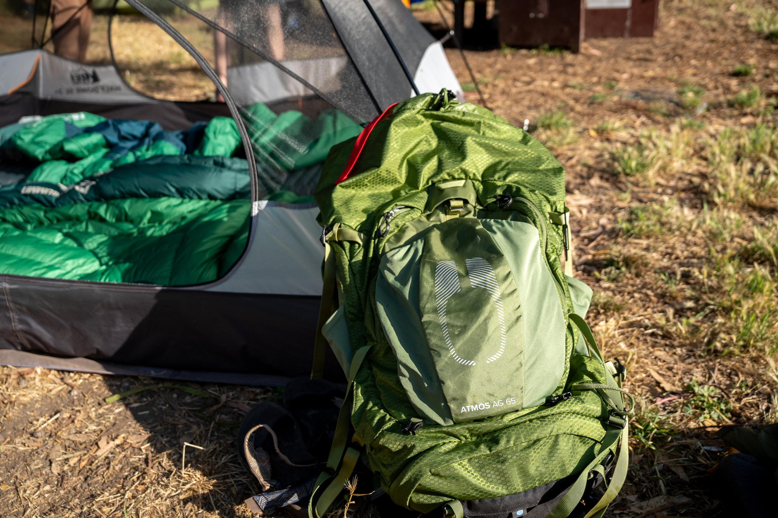 a backpacking backpack next to a tent