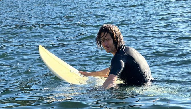 a surfer sits in the water waiting for a wave 