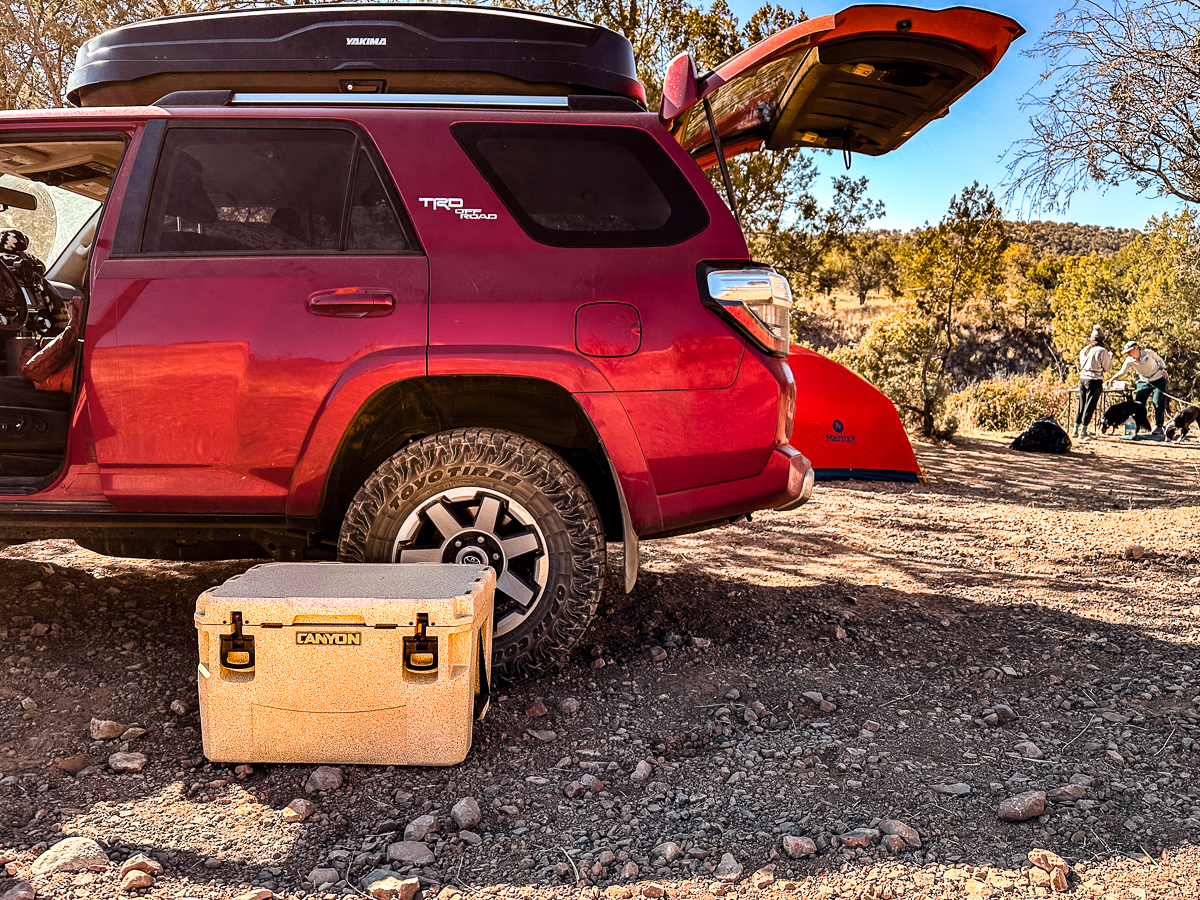 cooler in front of car at campsite