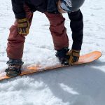 man strapping in snowboard bindings