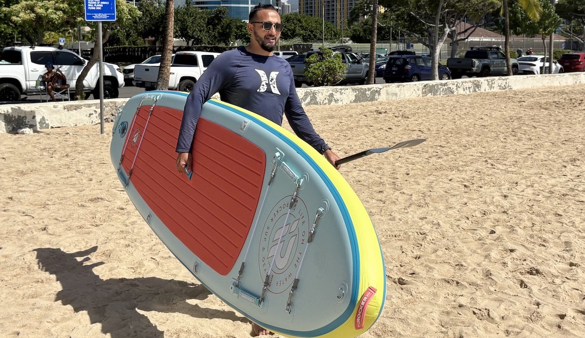 a man carrying a paddle board