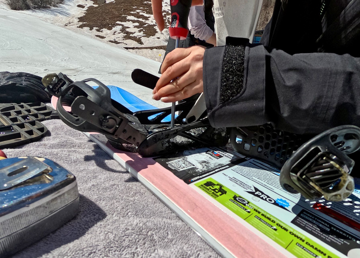 woman adjusting snowboard bindings