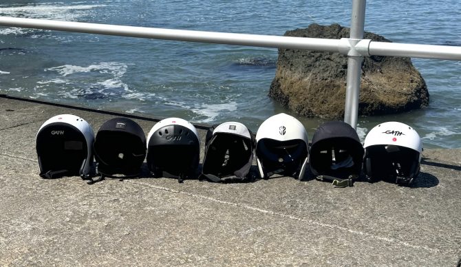 Surf helmets lined up by the water