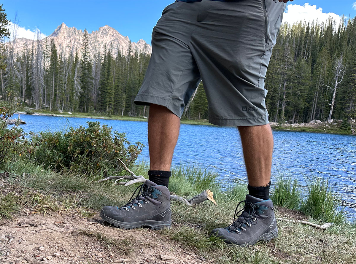 a closeup of the scarpa kailash trek hiking boots next to a lake in the mountains