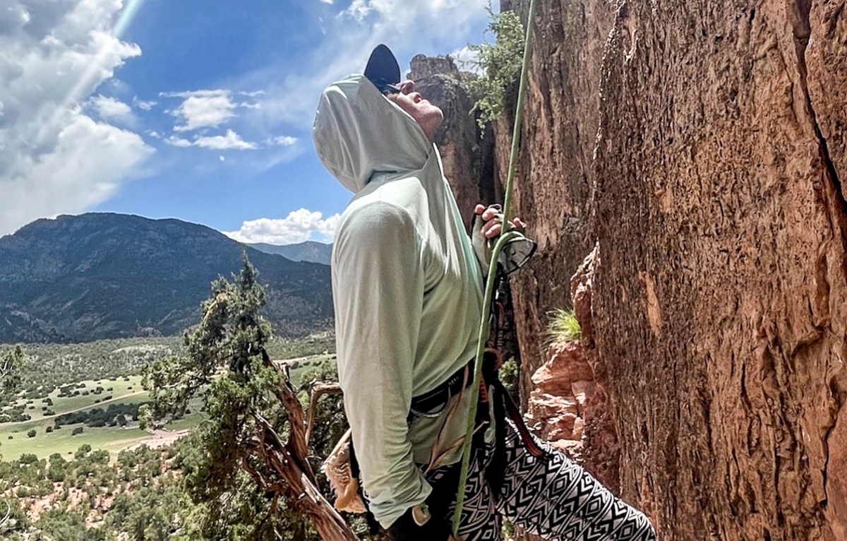 man belaying in sun shirt